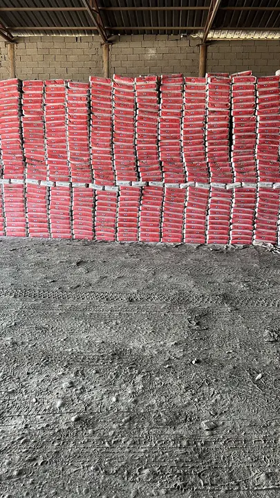 Stacks of Çimsa white cement bags arranged in a warehouse