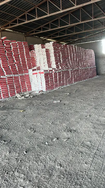 Stacked red and white cement bags in a warehouse