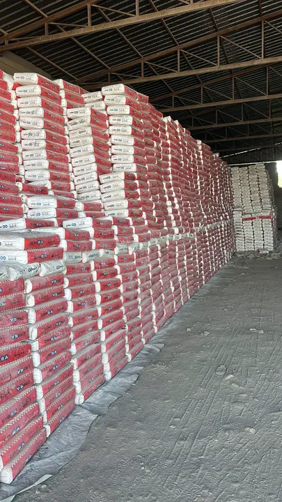 Cement bags stacked in long rows in a warehouse